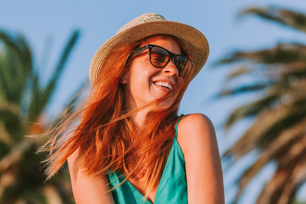 Young woman enjoying the view by the palm trees